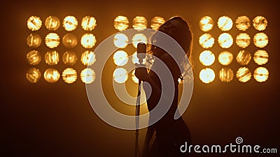 Silhouette woman singer moving seductively in studio. Hot girl singing solo. Editorial Stock Photo