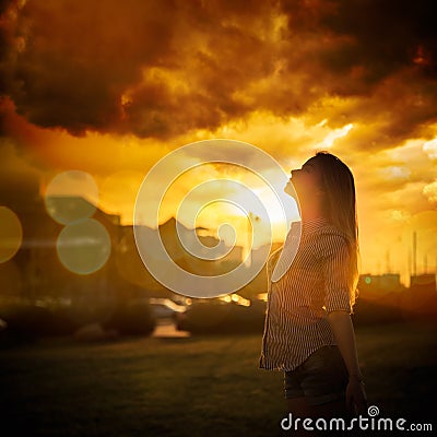 Silhouette of Young Woman at Urban Sunset Stock Photo