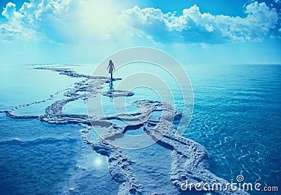 Silhouette of a young woman walking along the shore of the Dead Sea Stock Photo