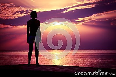 Silhouette of Young Woman Watching Sea Sunset Stock Photo