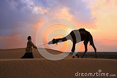 Silhouetted bedouin walking with his camel at sunset, Thar desert near Jaisalmer, India Editorial Stock Photo