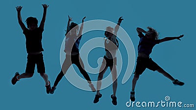 Silhouetted full length shot of four little sportive kids looking joyful while posing, jumping isolated over blue Stock Photo