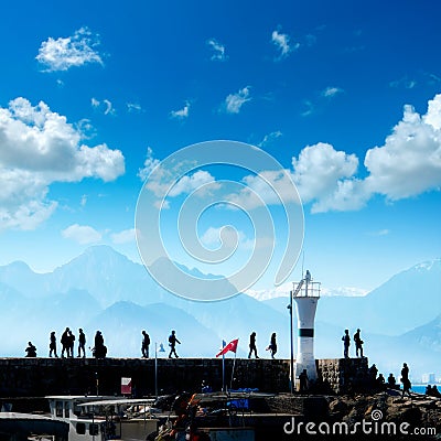 Silhouetted people walking in Antalya harbor Stock Photo