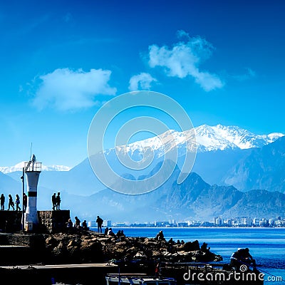 Silhouetted people walking in Antalya harbor Stock Photo