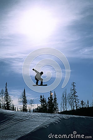 Silhouetted Snowboarder Jumping Stock Photo