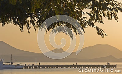Silhouettes of branches of acacia,mount, pier,boats Stock Photo