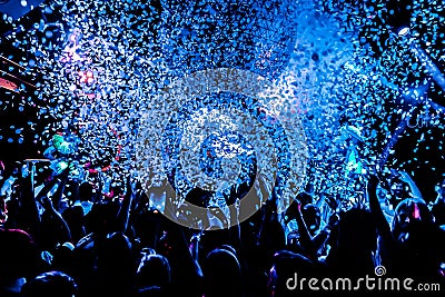 Silhouettes of concert crowd in front of bright stage lights with confetti Editorial Stock Photo