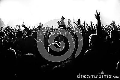 Silhouettes of concert crowd in front of bright stage lights with confetti Stock Photo