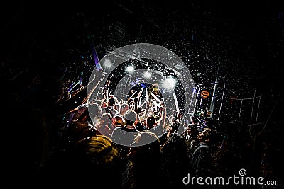 Silhouettes of concert crowd in front of bright stage lights with confetti Editorial Stock Photo