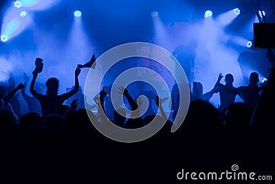 Silhouettes of the concert crowd in front of bright stage lights Editorial Stock Photo