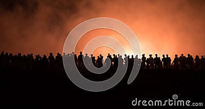 Silhouettes of a crowd standing at field behind the blurred foggy background. Revolution, people protest against government, man f Stock Photo