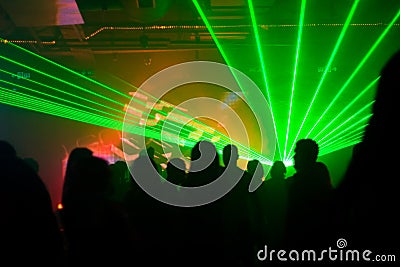 Silhouettes of dancing people in green laser light Stock Photo
