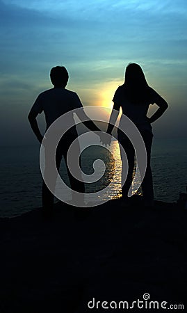 The silhouettes depict the love of couples with beautiful sunset backdrop. Stock Photo