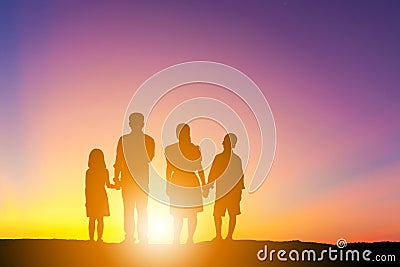 Silhouettes of father mother son and daughter playing and relaxing at sunset evening sky background Stock Photo