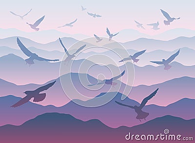 Silhouettes of flying birds over mountains Stock Photo