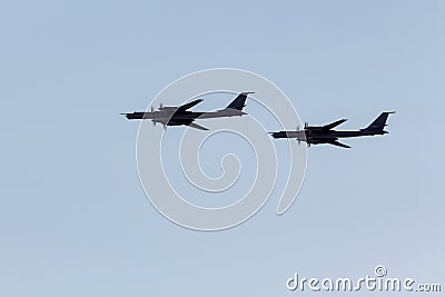 Silhouettes flying Russian Tu-95 turboprop strategic bombers against the sky. Stock Photo