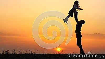 Silhouettes of happy child rushes into hands of father. Stock Photo