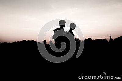 Silhouettes of kids hiking at sunset Stock Photo