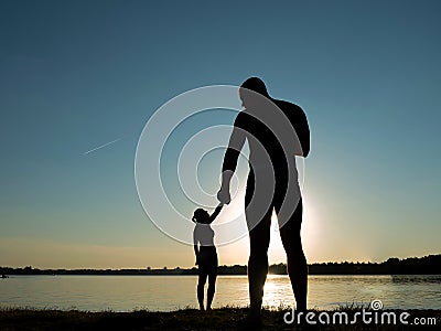 Silhouettes of a loving couple on the beach. Sunset on the beach. Giant and baby Stock Photo