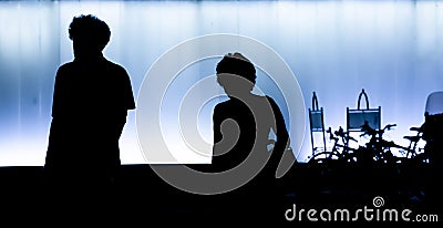Silhouettes of man and woman walking in the night in high contrast black and white Stock Photo