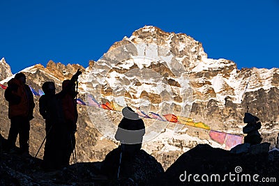 Silhouettes of Mountain Climbers staying against high Peaks Stock Photo