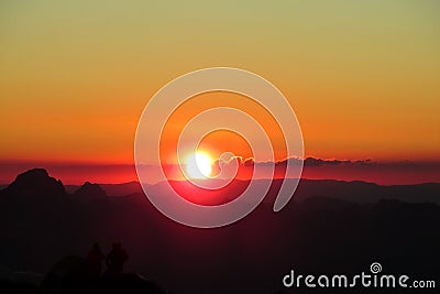 Silhouettes of people ant tents in the mountains at sunset light Stock Photo