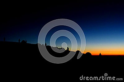 Silhouettes of people ant tents in the mountains at sunset light Stock Photo