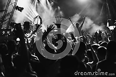 Silhouettes of people at a concert in front of the scene in bright light. Black and White Editorial Stock Photo