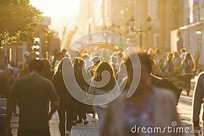 Silhouettes of people crowd walking down the street at summer evening, beautiful light at sunset Editorial Stock Photo