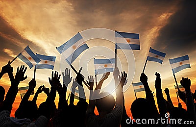 Silhouettes of People Holding Flag of Argentina Stock Photo