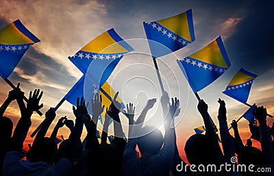 Silhouettes of People Holding Flag of Bosnia and H Stock Photo