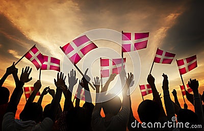 Silhouettes of People Holding the Flag of Denmark Stock Photo