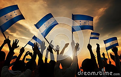 Silhouettes of People Holding Flag of Honduras Stock Photo