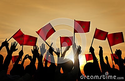 Silhouettes of People Holding the Flag of Morocco Stock Photo