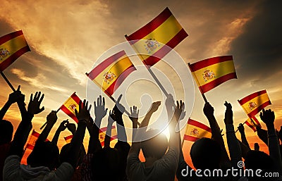 Silhouettes of People Holding Flag of Spain Stock Photo