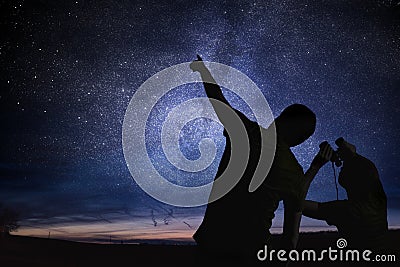 Silhouettes of people observing stars in night sky. Astronomy concept Stock Photo