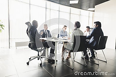 Silhouettes of people sitting at the table. A team of young businessmen working and communicating together in an office Stock Photo