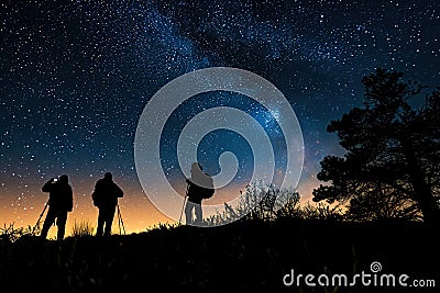 Silhouettes of people stargazing against a night sky Stock Photo