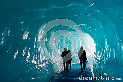 Silhouettes of people visiting thee ice cave of the Mer de Glace glacier, in Chamonix Mont Blanc Massif, The Alps France Stock Photo