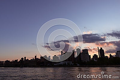 Manhattan and Roosevelt Island Skyline Silhouette during Sunset in New York City along the East River Stock Photo