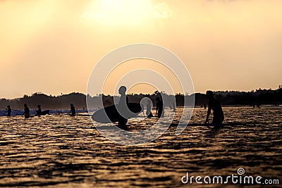 Silhouettes of surfers in the ocean at sunset Editorial Stock Photo