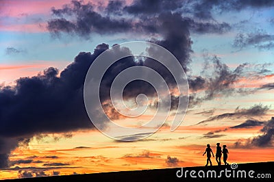 Silhouettes of three girls walking in the sunset Stock Photo