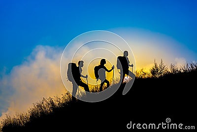 Silhouettes of three people walking with backpacks Stock Photo