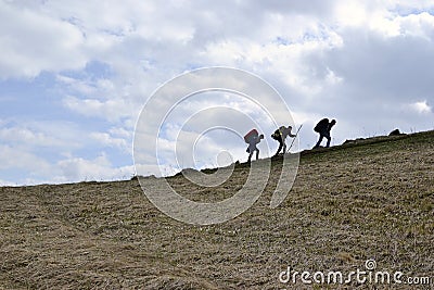 Three hikers climbing up the hill persons who go up the hiking trail in Carpathian mountains, Ukrainein mountains Editorial Stock Photo