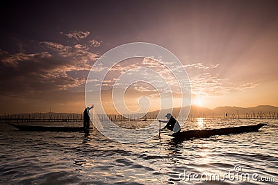 Silhouettes of the traditional fishermen throwing fishing net du Editorial Stock Photo