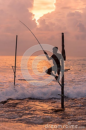 Silhouettes of the traditional Sri Lankan stilt fishermen on a stormy in Koggala, Sri Lanka. Stilt fishing is a method of fishing Editorial Stock Photo