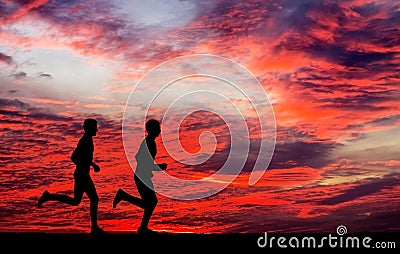 Silhouettes of two runners on fiery background Stock Photo