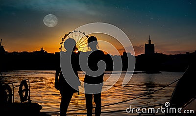 Silhouettes of two young girls at sunset Stock Photo