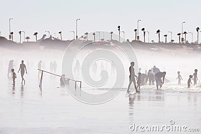 Silhouettes of various people playing football, walking and running at the beach in Morocco Editorial Stock Photo