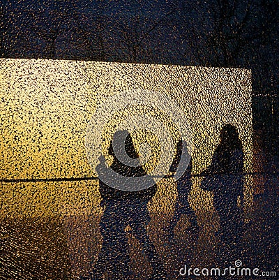 Silhouettes of walking people and trees seen through the broken window Stock Photo